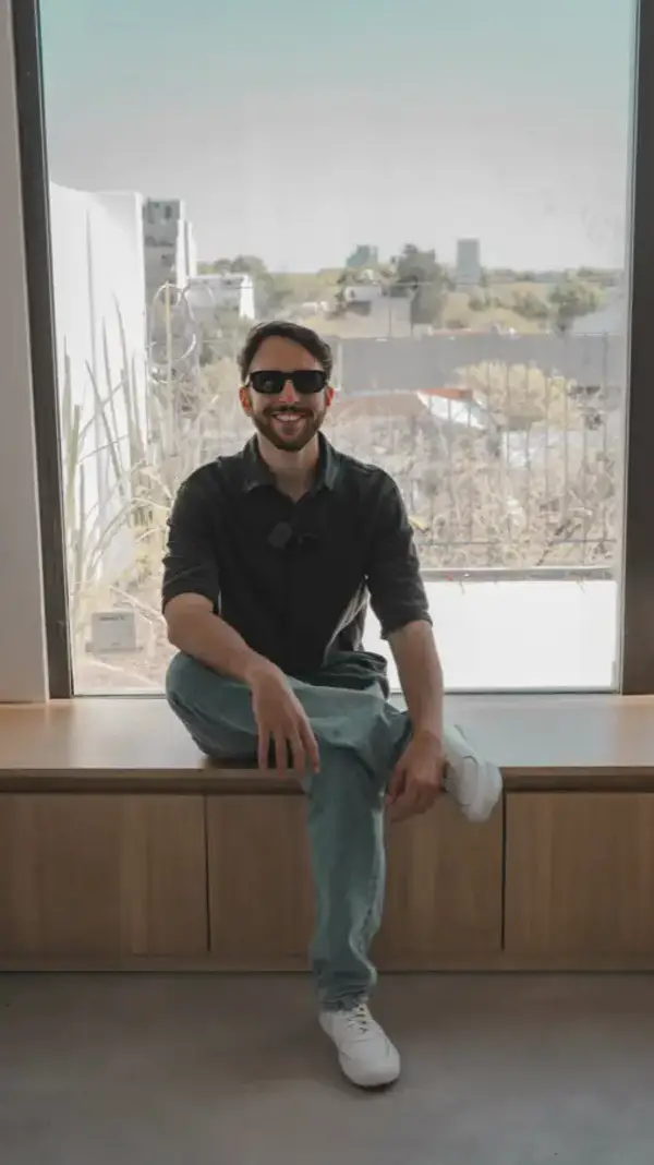 Leandro sentado en una obra terminada, con la ciudad de fondo