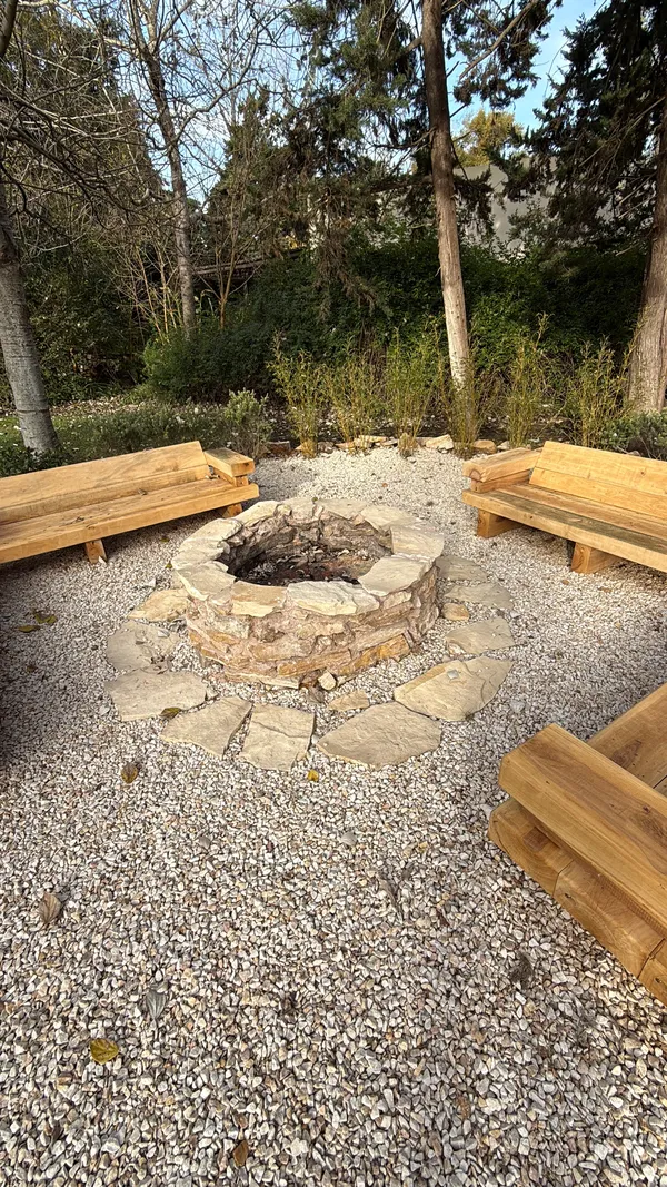 Bancos de madera alrededor del fogonero de piedra